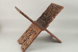 AN ASIAN -POSSIBLY THAI OR INDONESIAN CARVED OPENWORK WOODEN FOLDING BOOK STAND, 77cm (closed).
