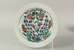 A 19TH CENTURY OR EARLIER IZNIK STYLE EUROPEAN -PROBABLY FRENCH POTTERY DISH, painted with flora,