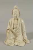 A 17TH CENTURY BLANC-DE-CHINE SEATED FIGURE, 22cm high.