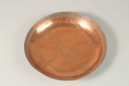 A PERSIAN SIGNED TINNED COPPER DISH, with a band of engraved decoration to the interior rim, the