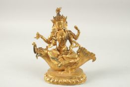 A FINELY GILDED BRONZE FIGURE OF A DEITY SEATED UPON A BEAST, 26cm high.