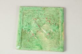 AN 18TH-19TH CENTURY MUGHAL INDIAN GREEN GLAZED POTTERY TILE, 18cm x 18cm.
