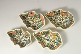FOUR JERUSALEM GLAZED POTTERY LEAF-FORM DISHES, painted with flowers.