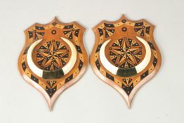 A FINE PAIR OF 19TH CENTURY ANGLO INDIAN EBONY INLAID ARMORIAL WALL MOUNTS WITH BOAR TUSKS, each