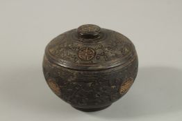 A CHINESE CARVED COCONUT LIDDED BOX, carved with longevity symbols and precious objects, 11.5cm