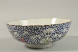 AN EARLY 20TH CENTURY CHINESE BLUE GROUND PORCELAIN BOWL, with enamel-painted bats and floral motifs