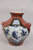 A LARGE CHINESE BULBOUS COPPER-RED BLUE AND WHITE PORCELAIN VASE, with moulded twin handles, painted