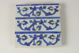 A FINE 17TH CENTURY PERSIAN SAFAVID CUERDA SECCA GLAZED POTTERY TILE WITH FLORAL DESIGNS, 20cm x