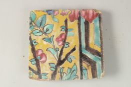 A 19TH-18TH CENTURY PERSIAN QAJAR YELLOW GLAZED POTTERY TILE, with floral decoration, 18cm x 18cm.