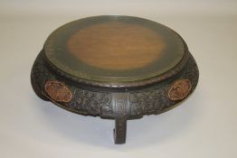 A CHINESE CARVED HARDWOOD CIRCULAR LOW TABLE, 20TH CENTURY, the top edge and frieze carved with