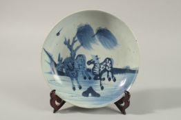 AN 18TH CENTURY QIANLONG CHINESE BLUE AND WHITE PORCELAIN DISH, painted with galloping horses,