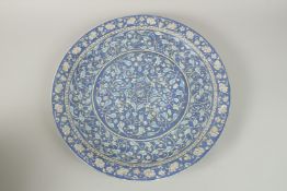 A LARGE TURKISH OTTOMAN IZNIK GLAZED POTTERY CHARGER, finely painted with intertwined foliate