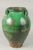 AN EARLY LARGE GREEN GLAZED POTTERY VASE - possibly 14th-15th century, with moulded handles to the