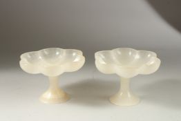 A PAIR OF NORTH INDIAN MUGHAL CARVED JADE PEDESTAL BOWLS, of lobed petal form, 15cm wide.