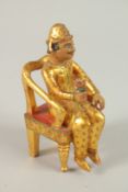 A VERY FINE BARODA CARVED GILT WOOD THRONED PRINCE FIGURE, C1900, the figure holding a flower in his