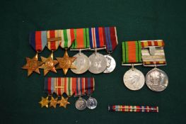 A group of WWII medals with matching miniature medals and other items.