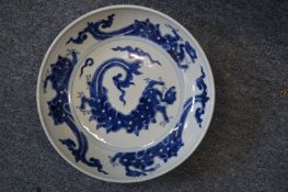 A Chinese circular blue and white dish decorated with dragons.