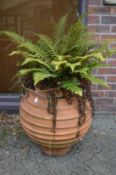 A large ribbed design faux terracotta planter with fern.