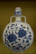 A Chinese blue and white moon flask painted with flowers.