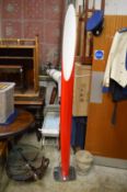A stylish red perspex floor standing lamp.