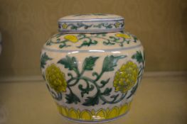 A Chinese pale green ground ginger jar and cover decorated with bands of flowers.
