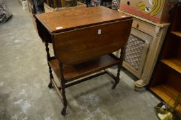 An oak drop-leaf trolley.