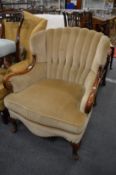 A mahogany framed armchair with beige upholstery.