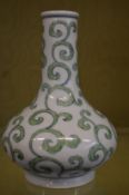 A Chinese bottle shaped vase with a scrolling green ground design.