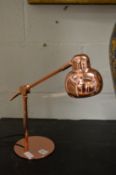 A pair of copper angle poise lamps.