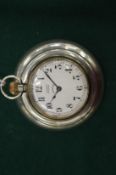 An Asprey pocket watch in a silver watch holder.