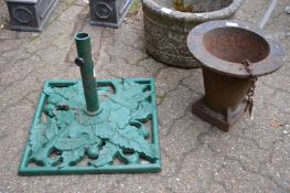 A cast iron parasol base and another item.