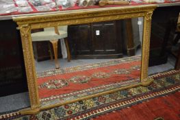 A gilt framed over-mantel mirror.
