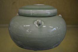 A Chinese pale green glazed circular bowl and cover with moulded hanging loops.