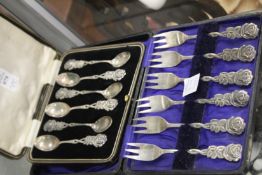 A cased set of cake forks with flower design handles together with a matching cased set of coffee
