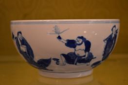 A Chinese blue and white bowl decorated with figures.