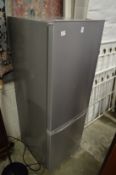 A small upright grey painted fridge/freezer.