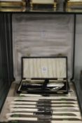 A cased silver three piece Christening set and a cased set of knives.