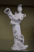 A Chinese blance de chine figure of a lady holding a basket of flowers.