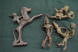 A group of three small erotic bronzes and a small bronze of a figure on horseback.