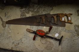 Three old carpenters saws and hand brace.
