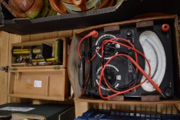 An Avometer together with a small brass microscope.