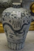A Chinese blue and white Meiping vase decorated with dragons, flowers and calligraphy.