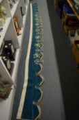A finely embroidered blue velvet bed hanging.
