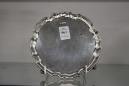 A silver salver with wavy rim on four scroll feet.