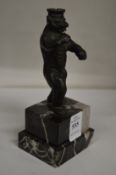 A small bronze of a standing bear wearing a crown on a marble base.