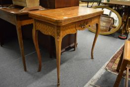 Continental style marquetry inlaid fold-over card table with ormolu mounts on cabriole legs.