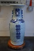 A large Chinese blue and white vase on wooden stand.