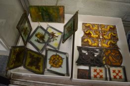A collection of small stained glass pictures and fragments.