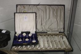 A set of twelve silver pistol grip handled butter knives, cased and a set of plated coffee bean