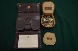 Box of dress studs and a folding playing card case.